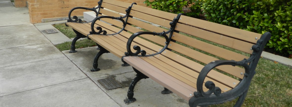 Photo of empty benches lining a sidewalk